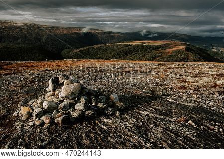 Dark Moody Northern Landscape, Cairn Stack Of Stones On A Mountain Rogne In Norway