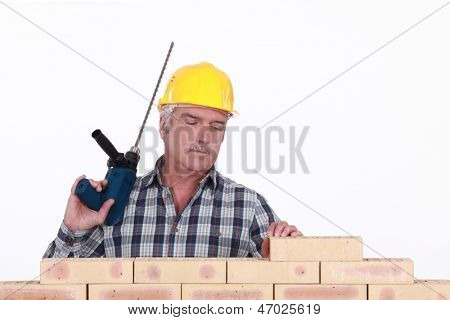 Un muratore con un trapano.