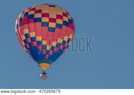 Hot Air Balloon In Flight. One Hot Air Ballooning Flying In The Sky In Switzerland. Chateau D'oex, V