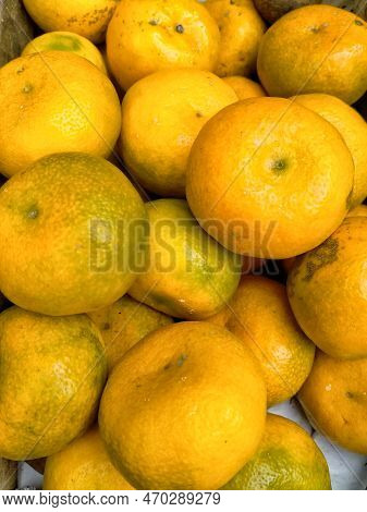 Yellow And Orange Colored Orange Fruits On Sale In A Market Stall