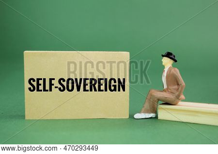 Miniature People And Paper With The Word Self-sovereign. The Concept Of Individual Freedom