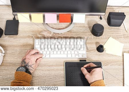 Top View Of Hand Holding Stylus On Graphic Tablet For Retouching Work. A Photographer Using An Editi