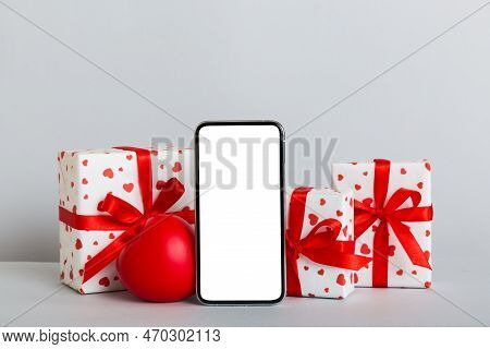 Mobile Phone With Blank Screen On Colored Background With Hearts, Calendar And Gift Box, Valentine D
