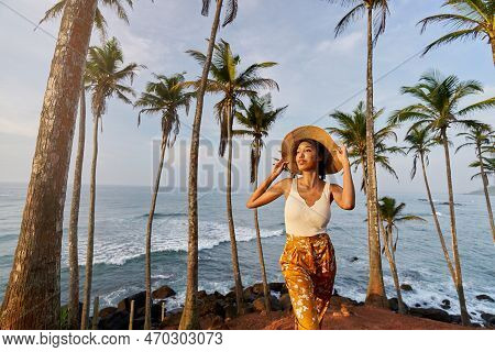 Young African Female Model Posing In Colorful Clothes At Tropical Location At Sunrise. Black Woman A