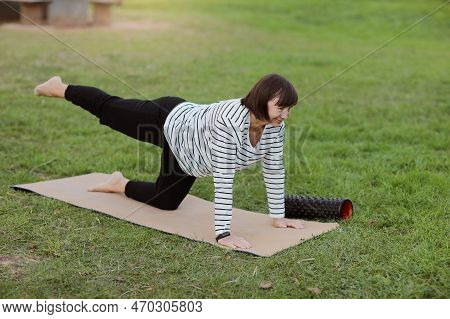 Caucasian Mature Adult Woman Doing Pilates Balance Exercise, Plank Position And Lifting Up Legs On F