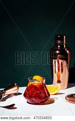 Boulevardier Alcoholic Cocktail With Bourbon, Vermouth, Bitters, Orange And Ice. Dark Green Backgrou