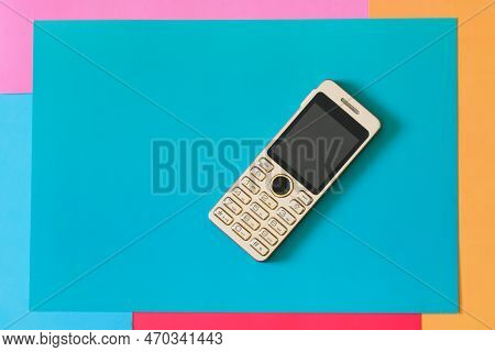 A Small Push-button Mobile Phone On A Colored Background. Close-up