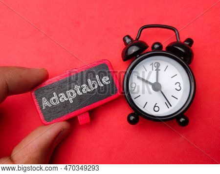 Hand Holding Wooden Board With Word Adaptable On Red Background.