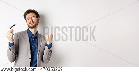 Excited Successful Businessman Dancing With Plastic Credit Card, Raising Fist Pumps And Smiling Deli