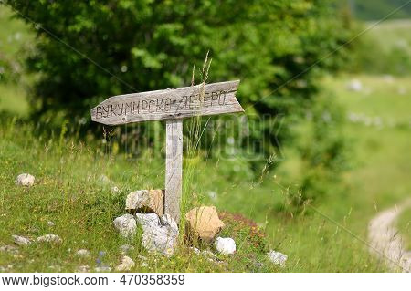Wooden Direction Sign On Bukumirsko Lake In The Valley Of The Dinaric Alps In Montenegro. Hiking And