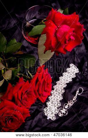 Beautiful red roses in vase with wine glass