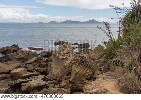 The View Of Rocky Coastline With Blue Sea And An Island On Background, Auckland, New Zealand.
