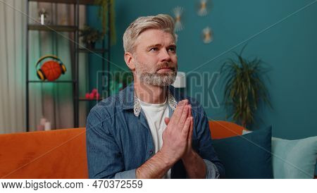 Please, God Help. Middle-aged Man Praying Sincerely With Folded Arms, Looking Upward And Making Wish
