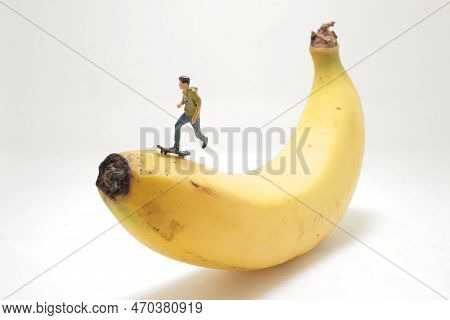 Mini Figure Of Skateboarder Jumping At Banana
