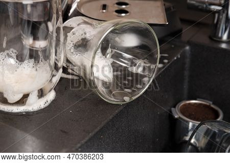 Washing Dishes Concept. Dirty Dishes With Foam From Detergent In A Black Stone Sink In The Kitchen T