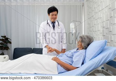 Senior Female Patient And Doctor. Asian Doctor With Stethoscope Check The Pules Of The Elderly Patie
