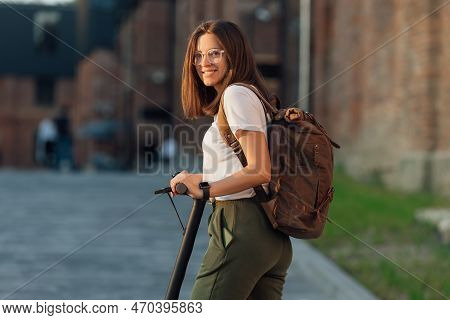 Young Woman Riding Electric Scooter In City Urban Street