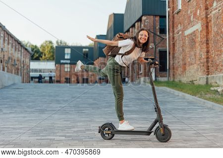 Young Woman Riding Electric Scooter In City Urban Street