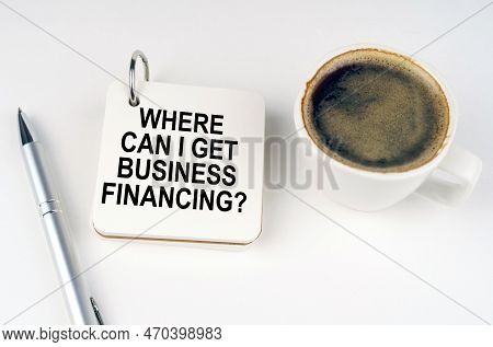 Business Concept. On A White Surface, A Cup Of Coffee, A Pen And A Notepad With The Inscription - Wh