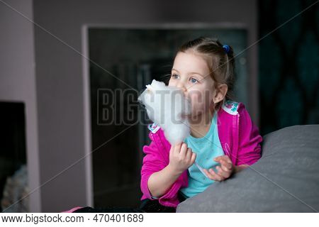 Little Girl Eat Sweet Cotton Candy At Home. Happy Kindergartener Bite Candy Floss. Favourite Sweets,