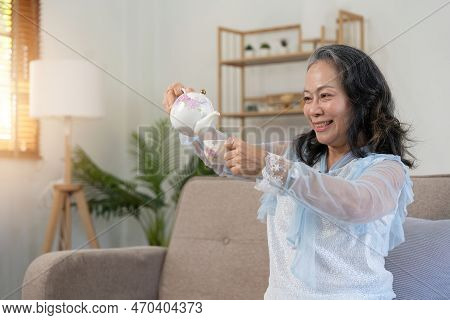 Happy Old Woman Drinking Healthy Tea At Home