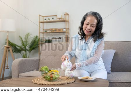 Happy Old Woman Eating Healthy Food At Home