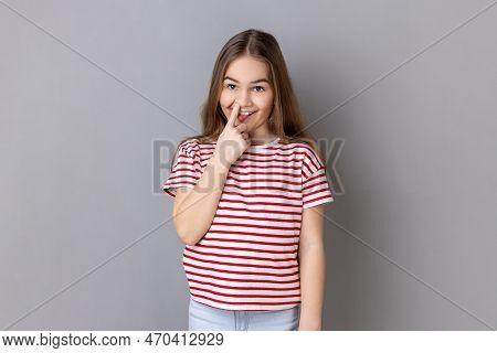 Portrait Of Weird Little Girl Wearing Striped T-shirt Holding Finger In Her Nose Showing Tongue, Unc
