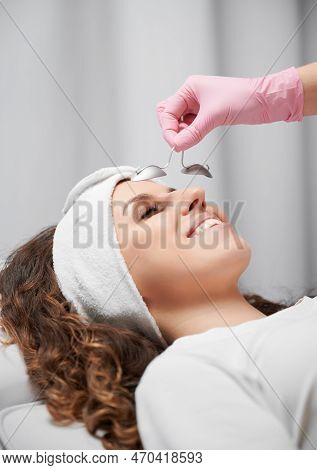 Cropped View Of Hand In Pink Rubber Glove Keeping Metal Eye Shield From Laservision On Short Distanc