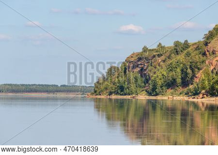 Lake Surrounded By Green Forest, Red Hill With Forest On Background