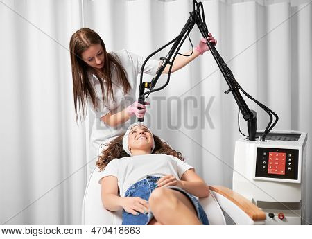 Female Doctor Cosmetologist Using Erbium Ablative Laser Machine While Performing Resurfacing Procedu