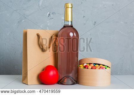 Bottle Of Wine On Colored Background For Valentine Day With Gift Box. Heart Shaped With Presrnt Box 