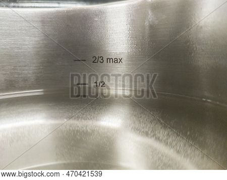 Stainless Steel Pressure Cooker At Work. Liquid Level Markings