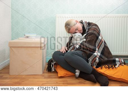Woman Sitting With Cat Under Blanket Warming Near An Electric Heater,