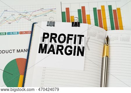 Business Concept. On The Business Charts Lies A Pen, A Notepad With Note Paper With The Inscription 