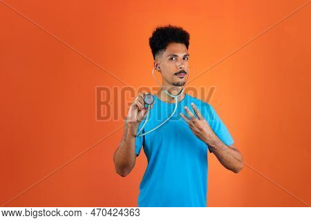 Doctor Or Veterinarian Isolated. Black Young Doctor Medical Resident With Stethoscope On Orange Back