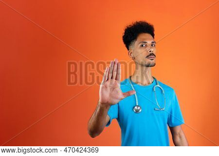 Doctor Or Veterinarian Isolated. Black Young Doctor Medical Resident With Stethoscope On Orange Back