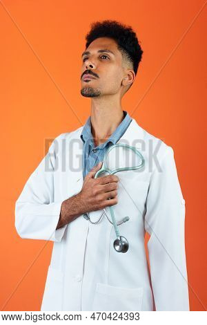 Doctor Or Veterinarian Isolated. Black Young Doctor Medical Resident With Stethoscope On Orange Back