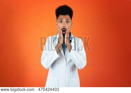 Doctor Or Veterinarian Isolated. Black Young Doctor Medical Resident With Stethoscope On Orange Back
