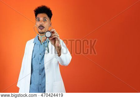 Doctor Or Veterinarian Isolated. Black Young Doctor Medical Resident With Stethoscope On Orange Back