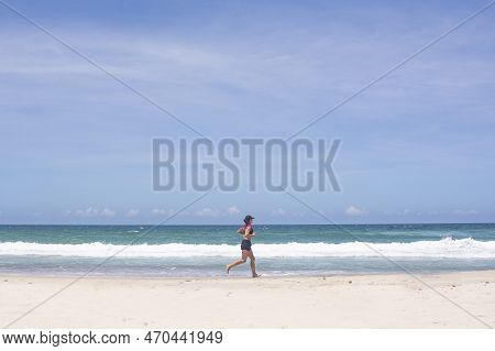 Florianopolis, Brazil - January 22, 2023 : A Girl Runs Along The Beach Barra Da Lagoa, Florianopolis