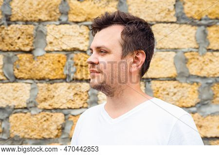 Male Man In White T-shirt On Stone Bricks From Limestone Laid Background. Lifestyle Looking Away Pro