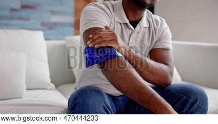 Man Using Ice Gel Pack On Injured Arm