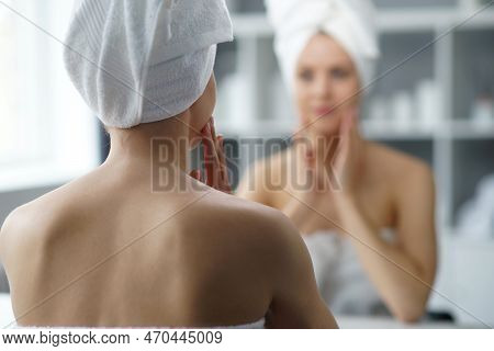 Young Woman Sits In The Bathroom In Front Of The Makeup Mirror And Does Cosmetic Procedures. Beautif