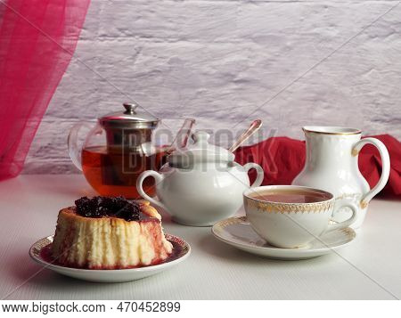 Сheesecake With Cherry Jam, Black Tea In A Teapot, A Cup With A Drink, On A Light Background. Delici