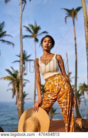 Young African Female Model Posing In Colorful Clothes At Tropical Location At Sunrise. Black Woman A