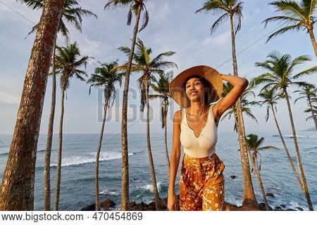 Young African Female Model Posing In Colorful Clothes At Tropical Location At Sunrise. Black Woman A