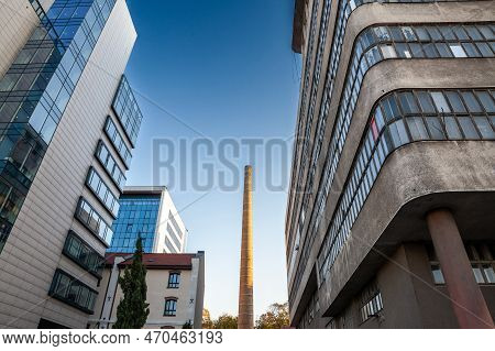 Abandoned Factory And Brick Chimney In Eastern Europe Next To A Modern And Renovated Business In Bel