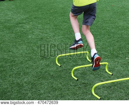 A Teenage Boy At Summer Pre Season Agility Practice Jumping Over Seix Inch Yellow Mini Hurdles One L