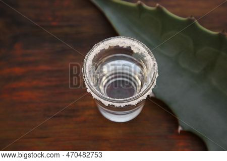 Mexican Tequila Shot With Salt And Green Leaf On Wooden Table, Above View. Drink Made Of Agava