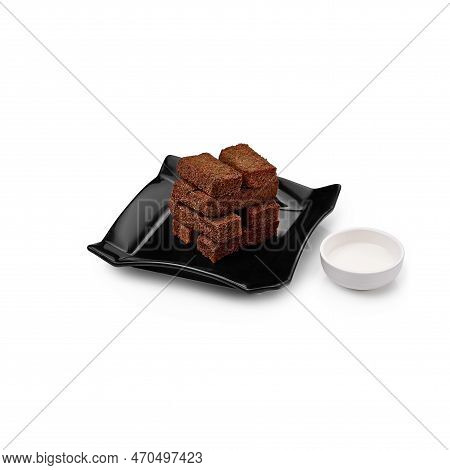 Croutons On A Black Plate With Garlic Sauce On A White Background Isolated